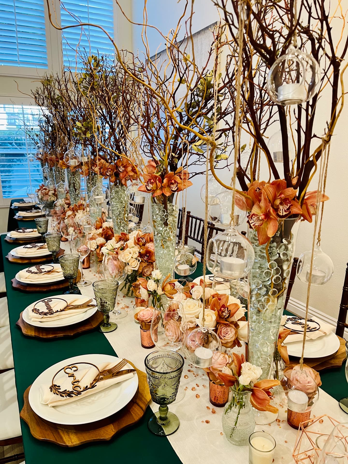 Emerald banquet table with copper orchids, manzanita branches and hanging votives