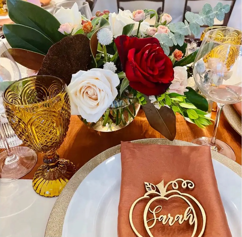 Terracotta place setting with amber glass, garden roses and a gilded name card