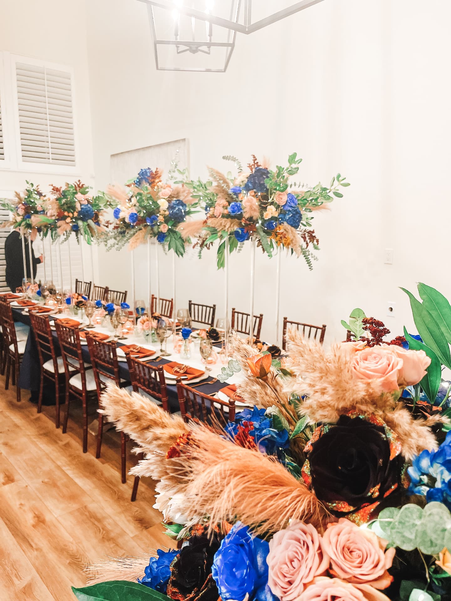 Navy and blush installation running the length of the dining room beneath lantern light