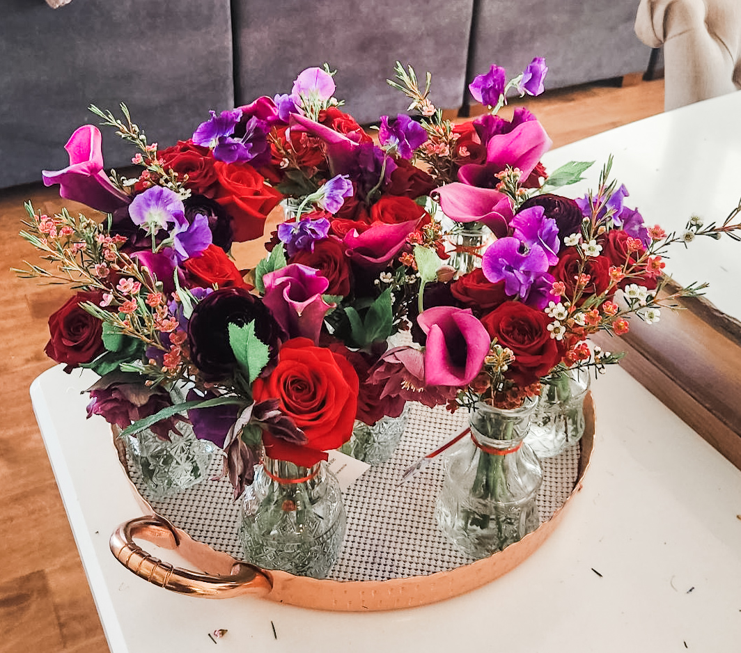 Copper tray of crystal bud vases with red rose, sweet pea and calla lily
